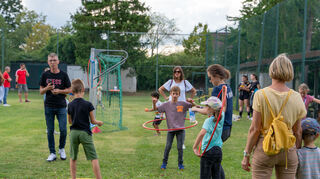 Viele Familien besuchen das Fest schon ab 16 Uhr und die Kinder machen begeistert bei den zehn Stationen der Kinderolympiade mit – wie hier beim Hula-Hoop.