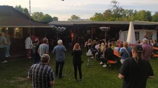 Als die Band zu spielen beginnt, stehen die ersten Gäste auf, um mitzufeiern.