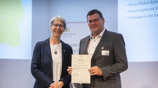 Staatssekretärin Elke Zimmer übergibt Bürgermeister Nils Drescher die Urkunde.