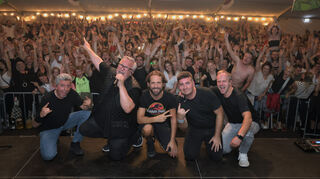 Das ist doch mal ein Foto: Hinten die grölende Partymeute, vorne diejenigen, die dafür verantwortlich sind: Radspitz mit Dirk Pandura (Basist), Klaus Pfreundner (Keyboard und Sänger), Johannes Klütsch (Drummer), Manuel Balzar (Gitarrist) und Lars Rau (Sänger).