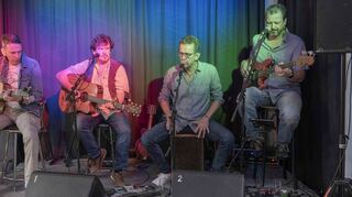 Die Seán-Treacy-Band – Andreas Bock (v.l.) an der Gitarre, Bandleader Seán Treacy ebenfalls Gitarre, Stefan Buchholz an der Cajon und Claus Bubik am Bass – weicht vom Biergarten in den Saal aus. Doch der Stimmung macht dies keinen Abbruch.