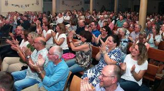 Es wurden zusätzliche Stuhlreihen vor den Kirchenbänken aufgestellt, damit alles Besucher Platz fanden. Ein Glas Wein genießt so manch einer auch während des Konzerts.
