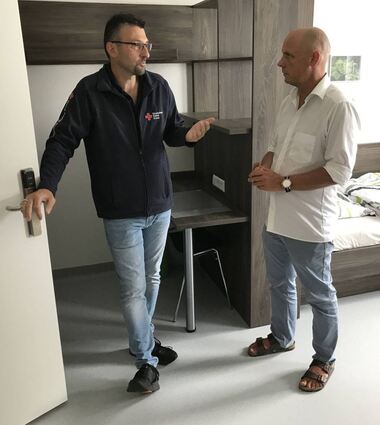 SPD-Politiker Daniel Born (r.) informiert sich bei Markus Unterländer im Quartier Auchtergrund über die Unterbringung von Obdachlosen.