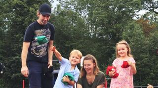 Arthur wirft bei der Kinderolympiade aufs Ziel, Papa Daniel, Mama Annika und Schwester Martha schauen zu.