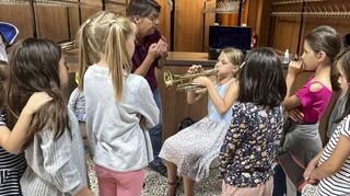 Lea entlockt der Trompete erste Töne. Die Ketscher Ferienkinder dürfen beim Musikverein verschiedene Instrumente ausprobieren.