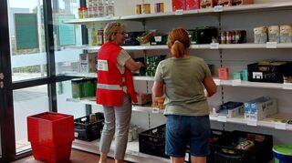 Zwei Ehrenamtliche beim Einräumen von Lebensmitteln.