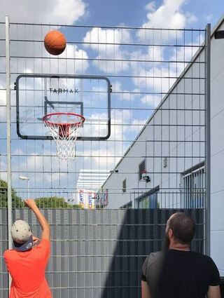 Betreuer Jens Petri (r.) spielt mit den Jugendlichen im Hof Basketball.