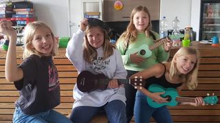 Marie (v. l.), Antonia, Klara und Ann-Sophie lernen beim Ferienprogramm des Kinder- und Jugendtreffs Point das Spielen einer Ukulele und singen dazu noch bekannte Lieder.