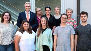 Bürgermeister Matthias Steffan (h. v. l.), Elke Heuser, Leiterin des Kindergartens „Spatzennest“, Personalrätin Yvonn Rogowski, Alisha Maier, Jugend- und Auszubildendenvertreterin und Simone Kirchner, Amtsleiterin, begrüßen die Auszubildenden Amelie Bährle (v. v. l.), Annika Schweizer und Mara Wohlfahrt (alle Verwaltungsfachangestellte), Sebastian Helm (Anerkennungs-praktikum im Rahmen der Ausbildung zum Erzieher) und Milan Pchalek (Duales Studium).