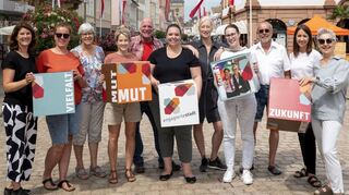 Der Arbeitskreis „Engagierte Stadt“ der Speyerer Freiwilligenagentur versammelt sich mit Kartonwürfeln zu einem Gruppenbild.