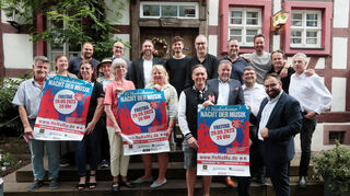 Fachleute vor Fachwerk: Vertreter von Veranstalter HMV, Organisator Stadthalle, Konzertlocations und Künstlern sowie Sponsoren präsentieren im Anschluss an die Pressekonferenz zur zehnten Hockenheimer Nacht der Musik vorm Wirtshaus „Güldner Engel“ die Plakate zum Konzertmarathon, der wieder auf große Vielfalt setzt.