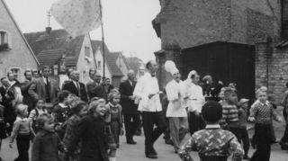 Adler-Wirt Karl Treiber (Mitte mit Gans) und zwei Kellner an der Spitze des Zuges durch Plankstadt. Hinter ihnen wird ein zur Fahne umfunktioniertes Tischtuch der Gaststätte durch die Gemeinde getragen.
