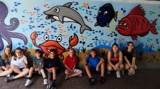 Tag zwei: Diese Truppe „zaubert“ einen Kraken, Krabben, Delfine und andere witzige Fische auf die Wand.