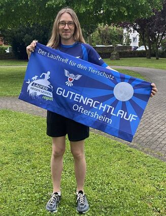 Patrick Alberti präsentiert voller Stolz das Banner des Joggingvereins.