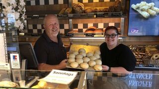 Der Geschäftsführer der Bäckerei Utz, Michael Utz, mit Mitarbeiterin Melanie Römer samt einem Blech frische Dampfnudeln.