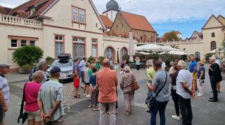 Die Wachenheimer und Schwetzinger Besuchergruppe bei der Führung im Hof der Sektkellerei Schloss Wachenheim.