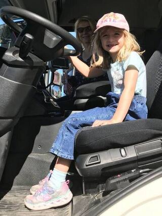 Lianna (5) sitzt mit Mutter Carol hinter dem Lenkrad eines Abfuhrfahrzeugs.