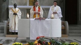 Mit vielen Erntegaben von Feldern und Gärten auf den Altarstufen: Pfarrer Christian Müller (M.), Pfarrer Marcel Brdlik (r.) und Kaplan Kizito feiern gemeinsam Eucharistie in St. Georg.