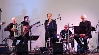 Die Gruppe „Moitié:Moitié“ – Christophe Loetz (Gesang), Hans-Jürgen Ott (Akkordeon), Dett Nolze (E-Gitarre), Victor Winter (E-Gitarre), Mario Cetto (E-Bass), Wolfram Sutter (Saxophon, Klarinette) und Christian Dobirr (Schlagzeug) – verzaubert das Publikum,