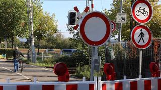 Die Sperrung des Bahnübergangs in der Grenzhöfer Straße ist deutlich durch Schilder gekennzeichnet. Trotzdem laufen viele auf die andere Seite – wie der Radfahrer im Hintergrund.
