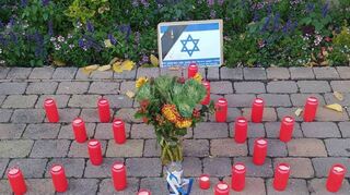 Ein Davidsstern aus brennenden Kerzen sowie die Blumen sollen dem Gedenken an die Opfer der Terroranschläge dienen.