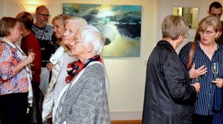 Vernissage-Gäste betrachten die vielschichtigen Exponate.
