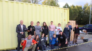 Startbereit für das Graffiti-Projekt auf dem Edeka-Parkplatz: die Jugendlichen aus Oftersheim mit Bürgermeister Pascal Seidel (v. l.), Jugendreferent Sebastian Längerer, Embach-Prokurist Antonino di Salvo und Künstler Michael Vogt (rechts unten, kniend).