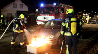 Das erzeugte Feuer am zweiten Unfallwagen wird von den Kameraden, ausgerüstet mit Atemmasken, in Teamarbeit gelöscht.