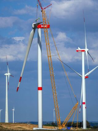 Ein Kran hebt auf der Baustelle eines neuen Windparks ein Rotorblatt für die Montage an das Generatorhaus. Könnte dies auch bald in Hockenheim beobachtet werden?Wünschenswert wäre es ...