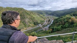 Der Blick von der Saffenburg bei Mayschoß nach Rech. Die Wander- und Genussregion Ahrtal hat viele dieser zauberhaften Aussichten zu bieten. Doch auch Spuren des Hochwassers sind noch da: Unten, mittig im Bild, ist die von der Flut zerstörte Bahnbrücke zu sehen.