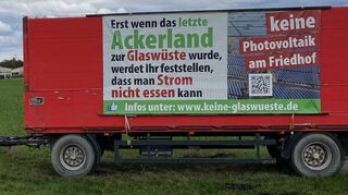 Biobauer Hubertus Merz warnt rund um die Gemeinde, auch vor seinem Betrieb im Hintergrund, mit Bannern vor den Folgen der weiteren Versiegelung von landwirtschaftlichen Flächen.
