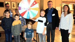 Am Glücksrad locken viele tolle Gewinne: Dekanatsreferent Raphael Brantzen (v. l.), Lucas, Christopher, Pfarrgemeinderätin Maria Sauer, Miriam, Tom, Dekan Uwe Lüttinger und Stefanie Joosten, im Dekanat Wiesloch für die Öffentlichkeitsarbeit zuständig, hoffen auf einen Treffer.