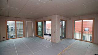 Blick in die offene Küche (r.), Wohnzimmer (l.) und Loggia. Trotz des exklusiven Outfits seien die Wohnungen auch für einkommensschwächere Familien bezahlbar.