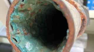 Das Bild zeigt eine gealterte Rohrinnenbeschichtung einer mit Epoxidharz sanierten Trinkwasserleitung.