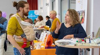 Jan Heidelberger mit Baby Gael Ignacio (drei Monate) am Stand der Stadtbibliothek Schwetzingen.