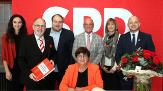Die Parteivorsitzende Saskia Esken (vorne) trägt sich in das Goldene Buch der Gemeinde Oftersheim ein. Dahinter v.l.: Jana Patzschke (stellvertr. Ortsvereinsvorsitzende), Jens Rüttinger, Florian Reck (stellvertr. Ortsvereinsvorsitzender), Daniel Born, Gudrun Wipfinger-Fierdel (stellvertr. Fraktionsvorsitzende) und BM Pascal Seidel.