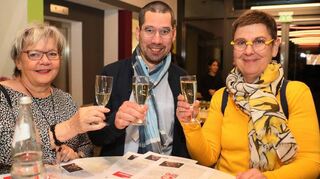 Sabine Rebmann (v. l.), Simon Abraham und Patricia Hempel stoßen beim Sektempfang auf das Jubiläum an.