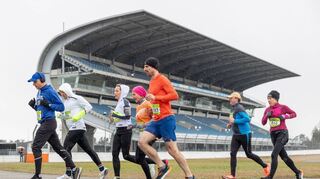 Zahlreiche Läuferinnen und Läufer trotzten dem winterlichen Wetter und den kalten Temperaturen am Hockenheimring – hier vor der Mercedes-Tribüne.
