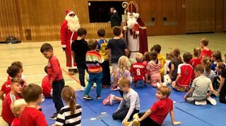 Auch hier legt eine Nikolaustruppe einen Stopp ein: Bei den Superminis und Minis der HG Oftersheim/Schwetzingen in der Hebelhalle schauen die Rotkittel vorbei, freuen sich über selbst gemalte Bilder der Kinder, die wiederum Geschenke erhalten.