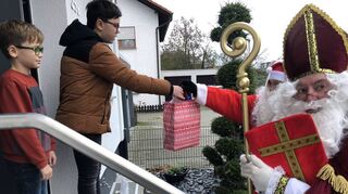 Tristan (9) und Julian (12) nehmen ihre Nikolausgeschenke an der Tür entgegen.