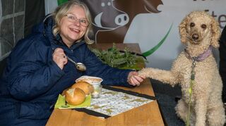 Birgit Zeh in Begleitung ihres Hundes lässt sich das pikante Wildschweinchili im Zelt des Förderkreises Wildgehege schmecken. Das Chili ist nur eines der kulinarischen Angebote beim Weihnachtsmarkt.