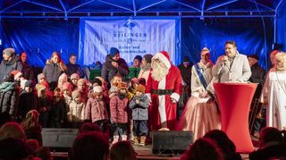 Bürgermeister Stefan Weisbrod (am Mikrofon), umrahmt von der Spargel- und Erdbeerprinzessin und dem Christkind, begrüßt zahlreiche Ehrengäste und alle Besucher des Adventsmarktes.