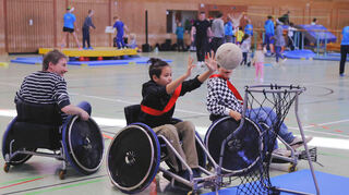 Kinder versuchen sich im Rollstuhl-Basketball.