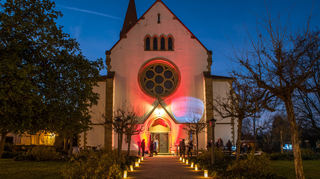 Auf dem Vorplatz der beeindruckend leuchtenden Kirche St. Kilian gibt es Glühwein, Kinderpunsch und Waffeln, die zum Verweilen und netten Gesprächen einladen.