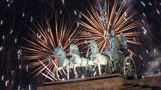 Feuerwerk zum Jahreswechsel 2023/2024 steigt während der Feier "Silvester am Brandenburger Tor" hinter dem Brandenburger Tor auf.