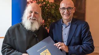 Oberbürgermeister Dr. René Pöltl (v.r.) nimmt das Goldene Buch der Stadt ganz unkonventionell auch mal mit zu einer Veranstaltung. Hier hat sich gerade Pater Anselm Grün beim Talk im Schloss im Rokokotheater eingetragen.