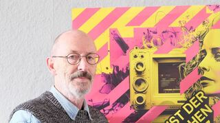 Kunstvereinsvorsitzender Friedrich W. Kasten vor dem – von einer KI generierten – Veranstaltungsplakat.