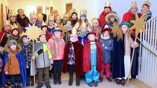 Mit einer großen Schar Sternsinger kommen Charlotte Jung-Cron und Rebecca Staender ins Rathaus zu Uwe Grempels, um den Segen zu überbringen.