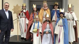 Bürgermeisterstellvertreter Heinz Kuppinger empfängt die Sternsinger vor dem Neulußheimer Rathaus.