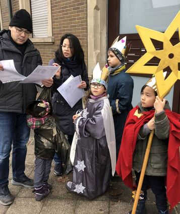 Anhdung Ta (l.) unterstützt seine Frau Tam Bui-Ta bei der Koordination der Besuche der Heiligen Drei Könige mit Sternträger – Naomi, Lina, Tristan und Samuel.